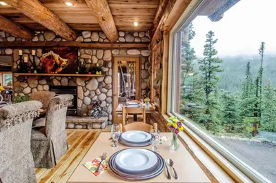 a dining table in a cabin with a large window at The Silver Lake Lodge - Adults Only in Idaho Springs