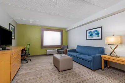 a living room with a couch and a tv at Holiday Inn Express & Suites Wheat Ridge-Denver West by IHG in Wheat Ridge