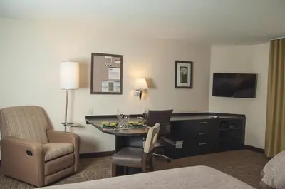 a hotel room with a desk and a chair at Candlewood Suites Fort Collins by IHG in Fort Collins