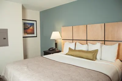 a hotel room with a large bed with a pillow at Candlewood Suites Fort Collins by IHG in Fort Collins