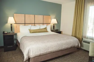 a hotel room with a large bed and two lamps at Candlewood Suites Fort Collins by IHG in Fort Collins