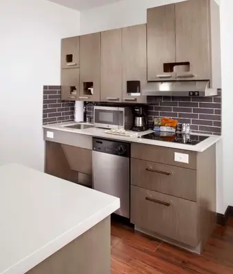 a kitchen with a sink and a stove top oven at Hyatt House Denver Lakewood Belmar in Lakewood