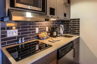 a kitchen with a sink and a stove top oven at Hyatt House Denver Lakewood Belmar in Lakewood