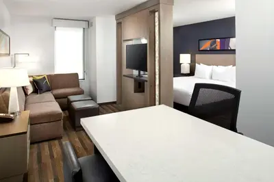 a hotel room with a bed and a couch at Hyatt House Denver Lakewood Belmar in Lakewood