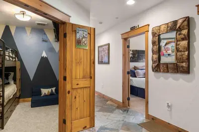 a hallway with a room with a bedroom and a bunk bed at Mount Victoria Lodge #D in Frisco