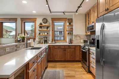 a kitchen with wooden cabinets and a stainless steel refrigerator at Mount Victoria Lodge #D in Frisco