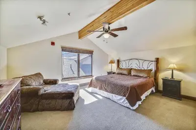 a bedroom with a bed and a couch and a ceiling fan at Marina Park 14C in Frisco