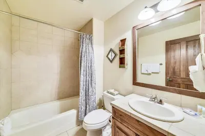 a bathroom with a sink and a toilet and a mirror at Marina Park 14C in Frisco
