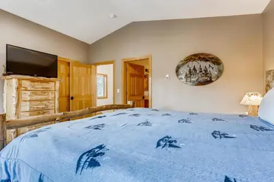 a bedroom with a blue bed with a flat screen tv at Streamside 333A in Frisco