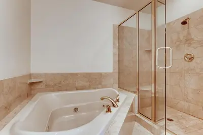 a bathroom with a tub and a glass shower at Streamside 333A in Frisco