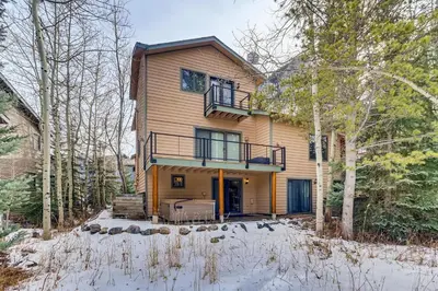 a house in the woods with snow on the ground at Streamside 333A in Frisco