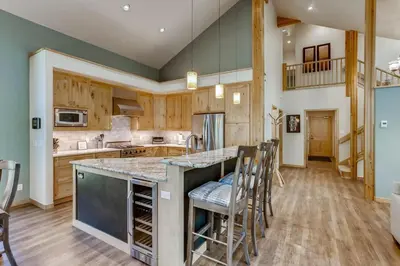 a kitchen with a large island with bar stools at Frisco Cedar Cabin in Frisco