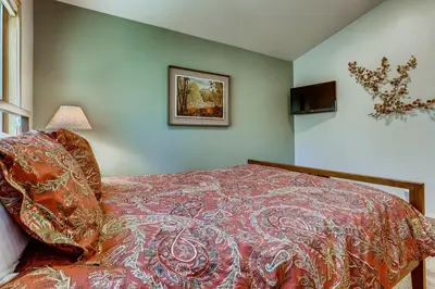 a bedroom with a bed and a picture on the wall at Frisco Cedar Cabin in Frisco
