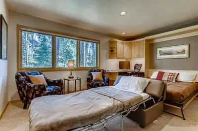 a bedroom with two beds and a desk and chairs at Frisco Cedar Cabin in Frisco