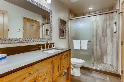a bathroom with a sink and a toilet and a shower at Frisco Cedar Cabin in Frisco