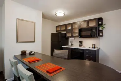 a kitchen and dining room with a table in a room at Candlewood Suites Denver North - Thornton by IHG in Thornton