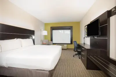 a hotel room with a bed and a desk and a television at Holiday Inn Express & Suites Ft Collins by IHG in Fort Collins