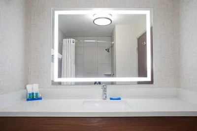 a bathroom with a sink with a large mirror at Holiday Inn Express & Suites Ft Collins by IHG in Fort Collins