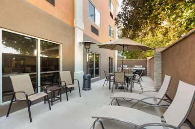 a patio with chairs and tables and an umbrella at Best Western Greeley in Greeley