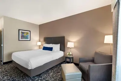 a hotel room with a bed and a chair at Best Western Greeley in Greeley