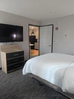 a hotel room with a bed and a flat screen tv at Candlewood Suites Loveland by IHG in Loveland