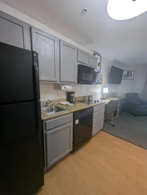 a kitchen with a sink and a black refrigerator at Candlewood Suites Loveland by IHG in Loveland