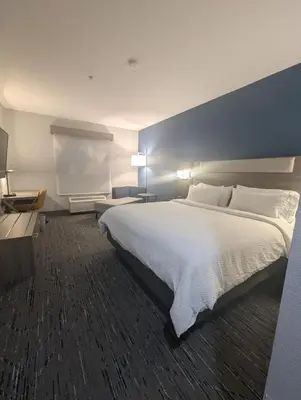 a hotel room with a large bed with white sheets at Holiday Inn Express Hotel & Suites Loveland by IHG in Loveland