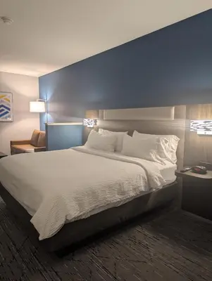 a bedroom with a large bed with a blue wall at Holiday Inn Express Hotel & Suites Loveland by IHG in Loveland