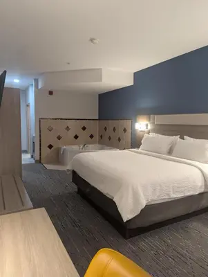 a bedroom with a large bed and a blue wall at Holiday Inn Express Hotel & Suites Loveland by IHG in Loveland