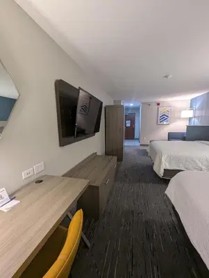 a hotel room with a desk and a tv on the wall at Holiday Inn Express Hotel & Suites Loveland by IHG in Loveland