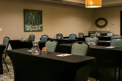 a conference room with tables and chairs and a painting at Holiday Inn & Suites Denver Tech Center-Centennial by IHG in Centennial
