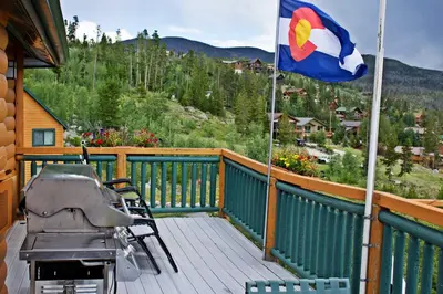 a patio with a flag and a grill on a deck at Gateway Inn in Grand Lake