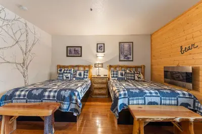 a bedroom with two beds and a tv at Gateway Inn in Grand Lake