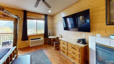 a room with a tv on the wall and a desk at Gateway Inn in Grand Lake