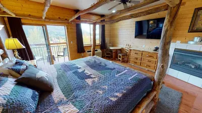 a bedroom with a large bed in a log cabin at Gateway Inn in Grand Lake