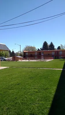 a field of green grass with a building in the background at Essex House Motel in Littleton