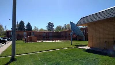a building with a flag on the side of it at Essex House Motel in Littleton