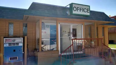 a office building with a sign on top of it at Essex House Motel in Littleton