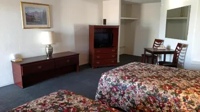 a hotel room with two beds and a television at Essex House Motel in Littleton