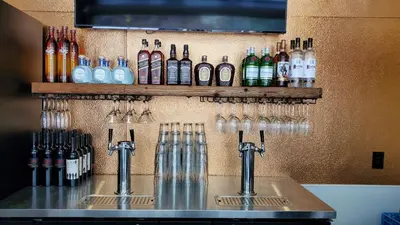 a bar with wine bottles and glasses on a wall at The Inn on Fall River & Fall River Cabins in Estes Park