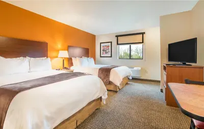 a hotel room with two beds and a flat screen tv at My Place Hotel-Loveland, CO in Loveland