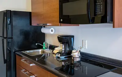 a kitchen with a sink and a coffee maker on a counter at My Place Hotel-Loveland, CO in Loveland