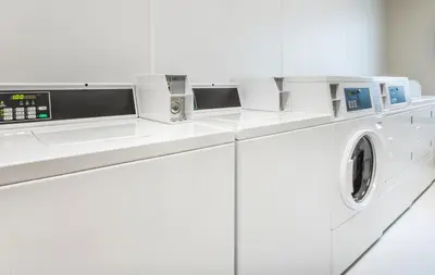 a white washing machine in a white laundry room at My Place Hotel-Loveland, CO in Loveland