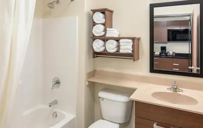 a bathroom with a toilet and a sink and a mirror at My Place Hotel-Loveland, CO in Loveland