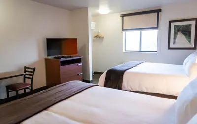 a hotel room with two beds and a flat screen tv at My Place Hotel-Loveland, CO in Loveland