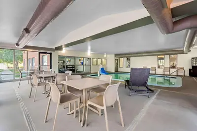 a room with tables and chairs and a pool at Comfort Suites Denver North - Westminster in Westminster