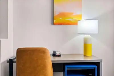 a desk with a yellow lamp and a chair at Comfort Suites Denver North - Westminster in Westminster