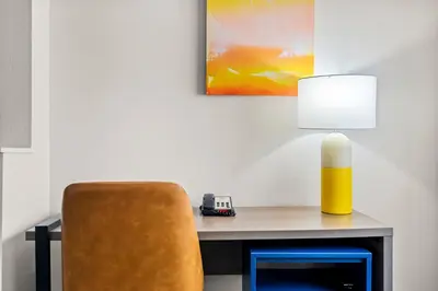 a desk with a yellow lamp and a chair at Comfort Suites Denver North - Westminster in Westminster