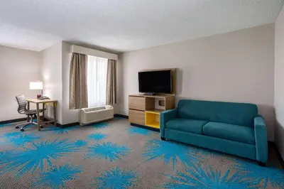 a living room with a couch and a television at Days Inn & Suites by Wyndham Denver International Airport in Denver