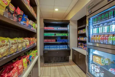 a drink aisle in a store with drinks and food at Days Inn & Suites by Wyndham Denver International Airport in Denver